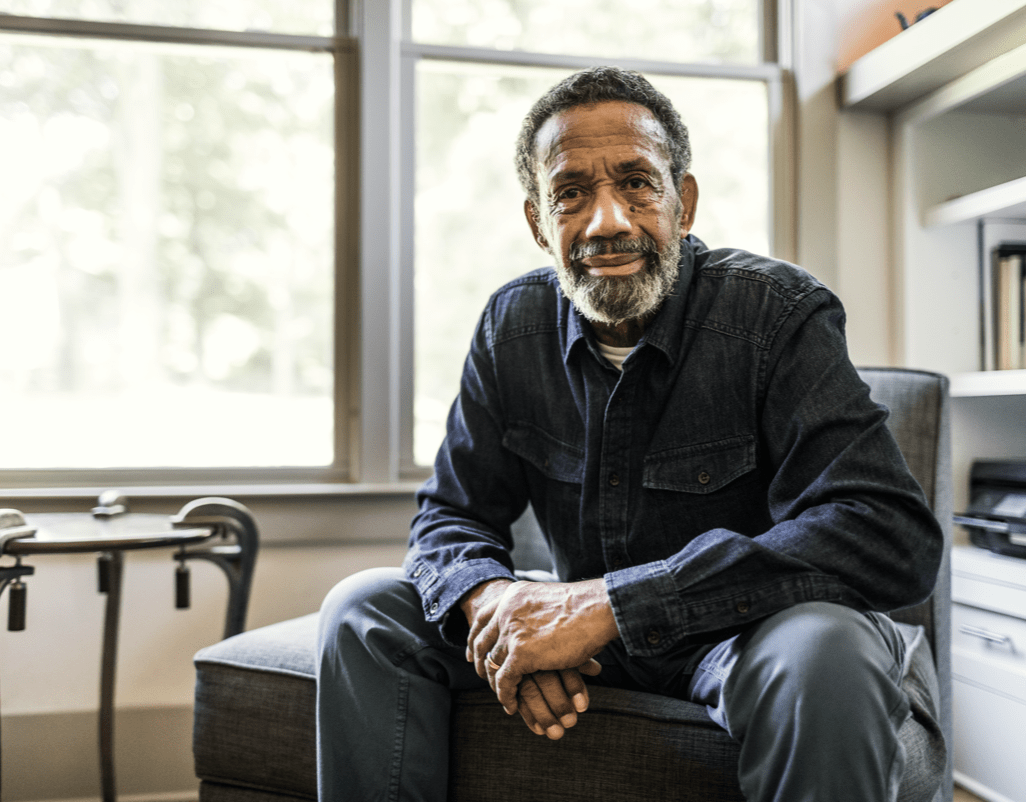 Man sat forward on chair looking at camera